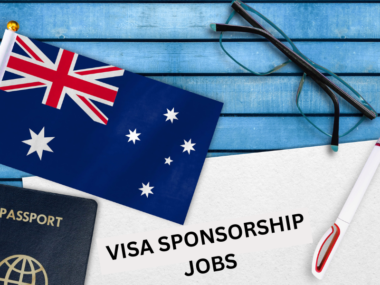 Australian flag, passport, and a document labeled "Visa Sponsorship Jobs" on a wooden desk, symbolizing work visa opportunities in Australia